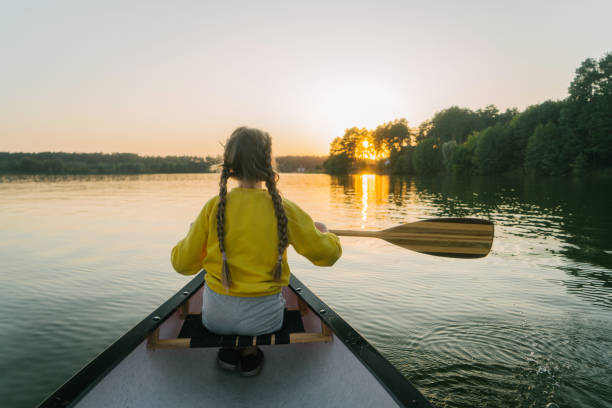 istock Girl canoeing on lake at sunset 1251577461