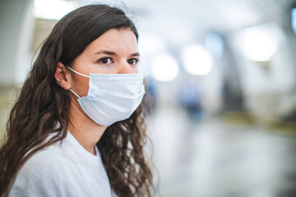 istock Young adult woman in face protective mask during quarantine using subway 1251577885