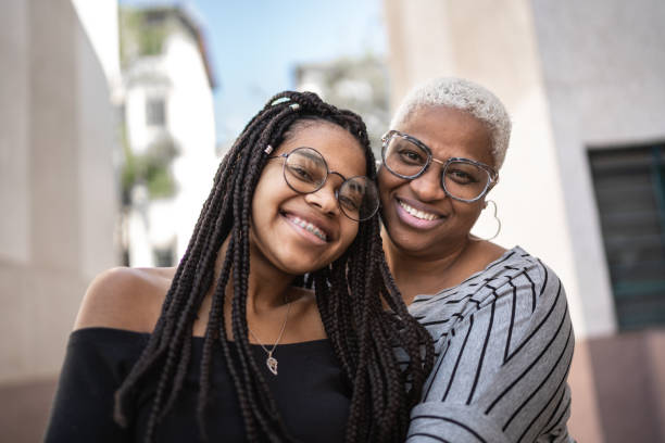 Portrait of mother and daughter embracing outside Portrait of mother and daughter embracing outside 18 19 years stock pictures, royalty-free photos & images