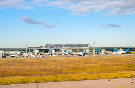 Airfield in sunshine, airplanes by the terminal modern building, Boryspil International Airport, Kyiv, Ukraine