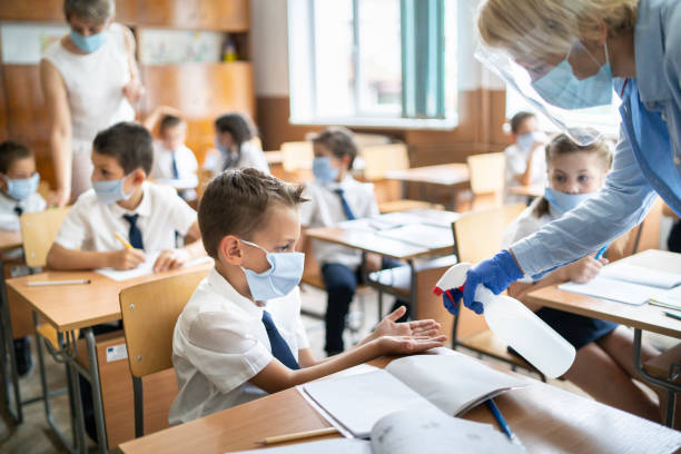 istock COVID-19.Using hand sanitizer in the classroom 1251580727