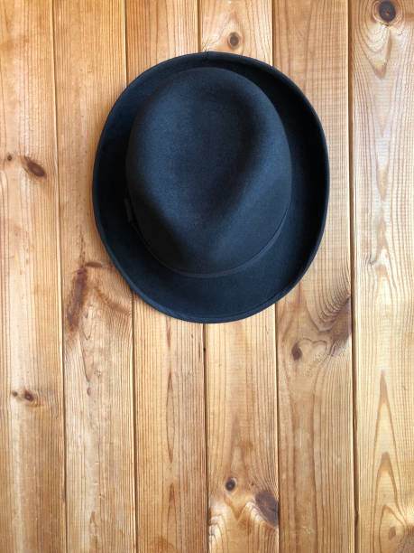 istock Black classic hat on a wooden background. 1251581807