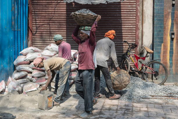 Delhi, India - March 3rd, 2020: Unidentified men work at construction site in Old Delhi, India. Manual labor is still widely used in construction industry of India.