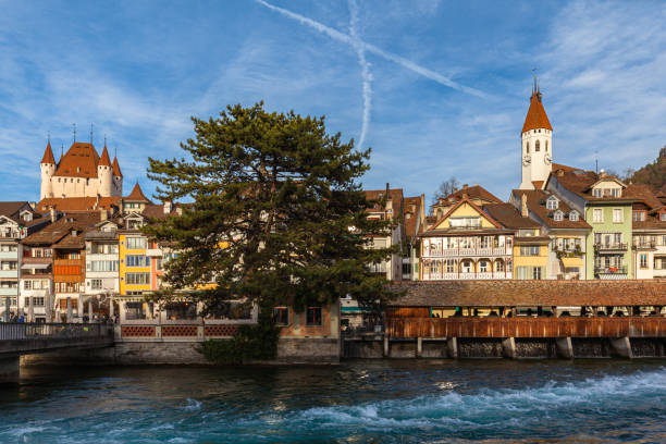 splendida vista panoramica del centro storico di thun dal lato del fiume aare in una soleggiata giornata autunnale con chiesa centrale, castello di thun e nuvola di cielo blu sullo sfondo, cantone di berna, svizzera. - thun cityscape famous place switzerland foto e immagini stock