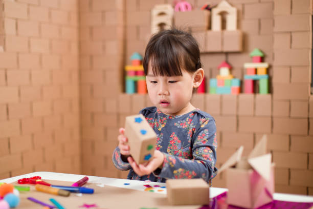 istock Preschooler making craft using cardboard blocks at home 1251585723