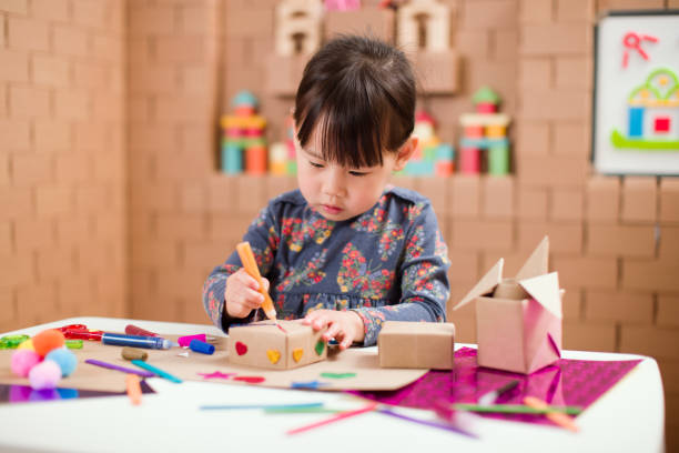 istock Preschooler making craft using cardboard blocks at home 1251585763