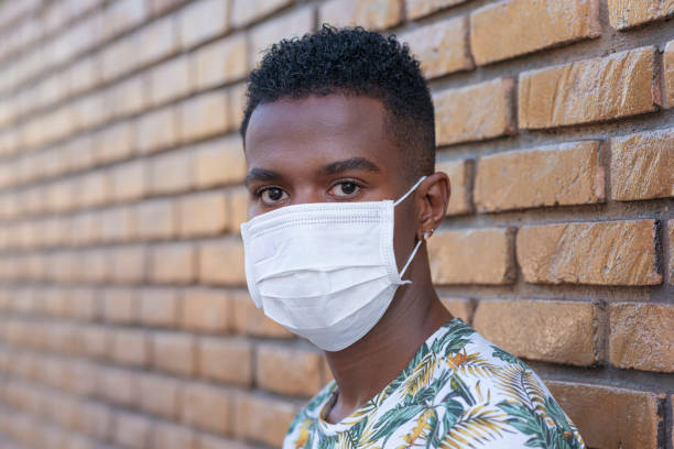 istock Portrait of young man using protective mask 1251585802