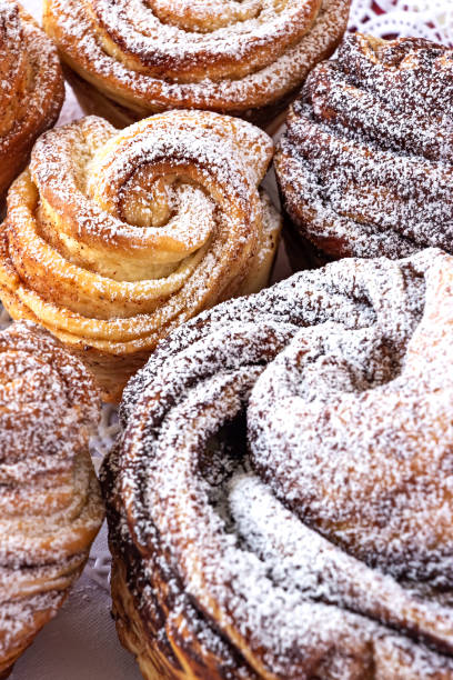 istock Homemade modern cruffin cake, yeast rolled cinnamon bun sprinkled powdered sugar. Copy space. Background. Close up. 1251585829
