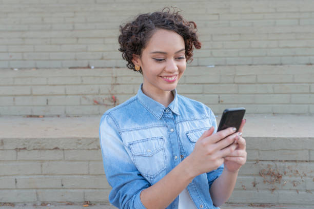 istock Young woman using mobile at street 1251587910