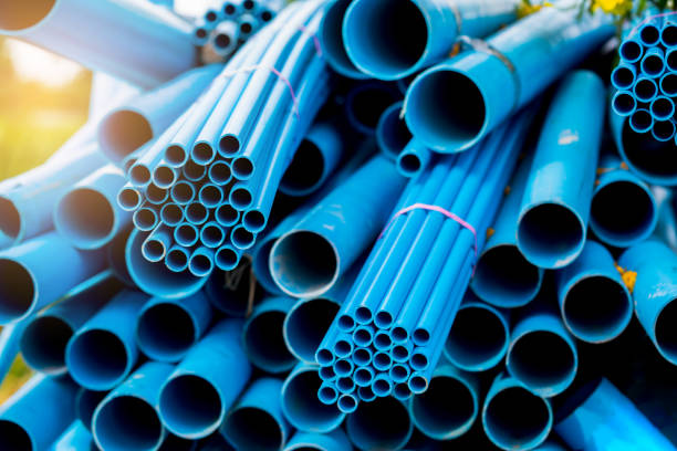 istock Selective to blue plastic pipe background. PVC pipes stacked in warehouse of construction site. 1251588140