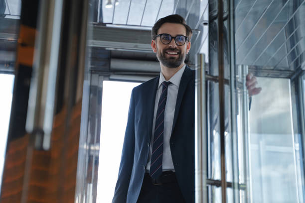 jeune homme d’affaires venant dans l’hôtel dans une bonne humeur - pushing men people business photos et images de collection