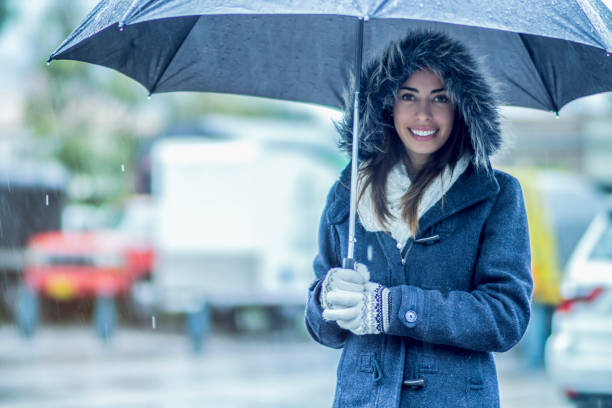 istock Woman outdoors on a rainy winter day using an umbrella 1251597643