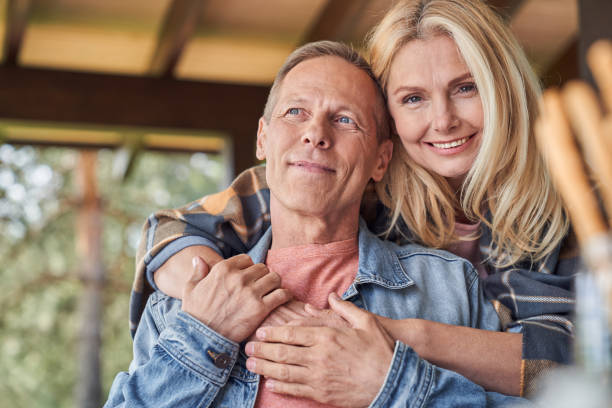istock Smiling mature woman hugging husband in open terrace 1251601497