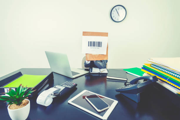 Young boy in a business suit with a barcode bag on his head. Young boy in a business suit with a barcode bag on his head. He is sitting in an office with a laptop computer and other technology. Just a number, hiding, no individuality concept embarrassment unrecognizable person wearing a paper bag human head stock pictures, royalty-free photos & images