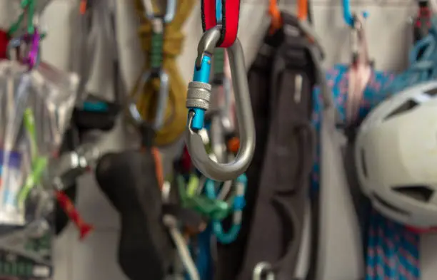 Screwgate carabiner attached to a nylon sling with a bunch of climbing gears on the background in Rio de Janeiro, RJ, Brazil