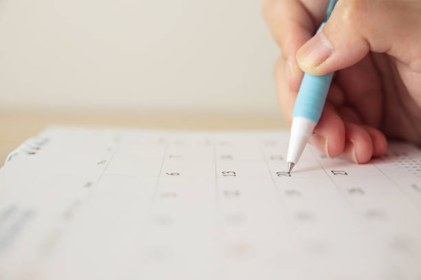istock Hand with pen writing on calendar date 1251611155