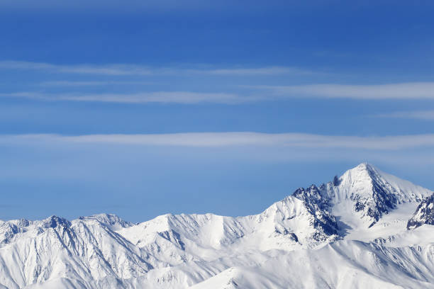 istock High snowy mountains and blue sky with clouds 1251612347
