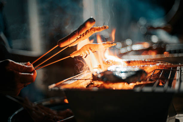 uma festa de churrasco noturno reunindo com preparação de alimentos com camarão e espeto de cachorro-quente - file sharing - fotografias e filmes do acervo