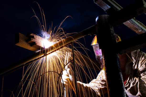 istock man doing welding work, by an arc manual apparatus, in the dark 1251632377