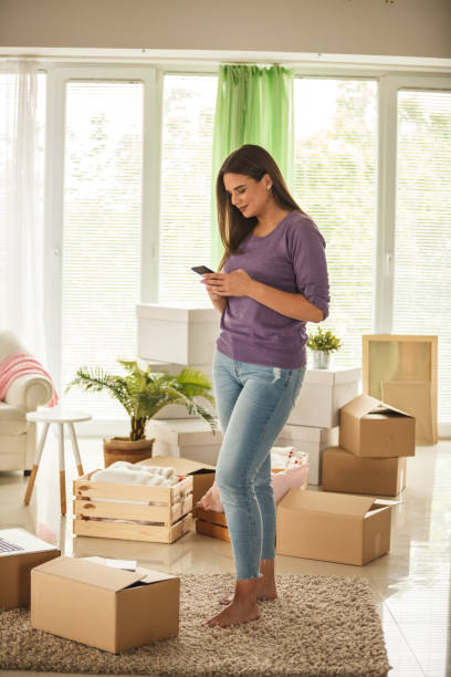 istock Young woman texting the movers after packing her apartment 1251633344