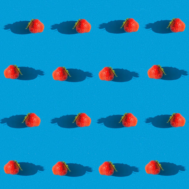 Seamless texture that depicts red strawberries on a yellow background. View from above. The apartment was lying. Repeating pattern.