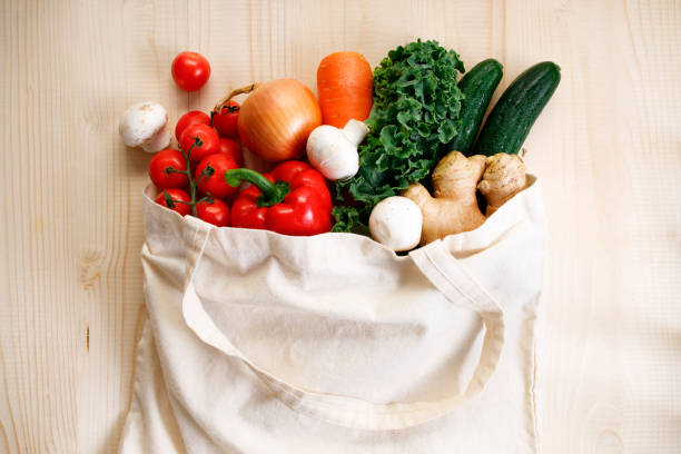 istock Fresh vegetables in cloth bag on light wooden background 1251643632