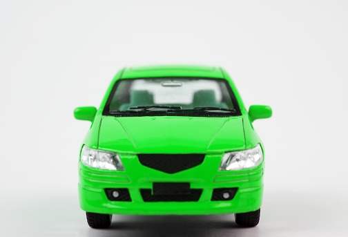 Close up of a children's toy mini racing car with an orange body and white tires