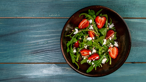 Spring salad with arugula, strawberries and ricotta. Food recipe background. space for text. top view