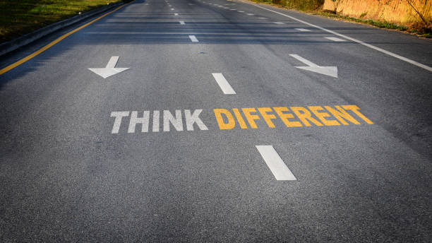 istock Think different word with white arrow and dividing lines on black asphalt road surface 1251654105