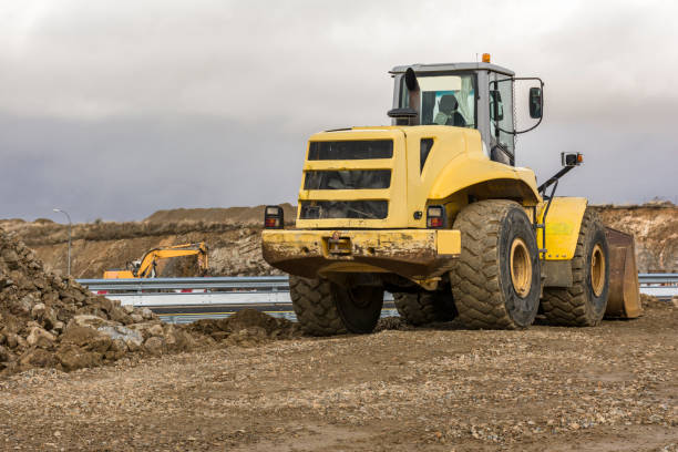 istock Yellow excavator moving earth at a construction site 1251654896
