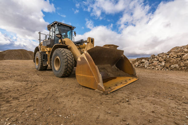 istock Yellow excavator moving earth at a construction site 1251654924
