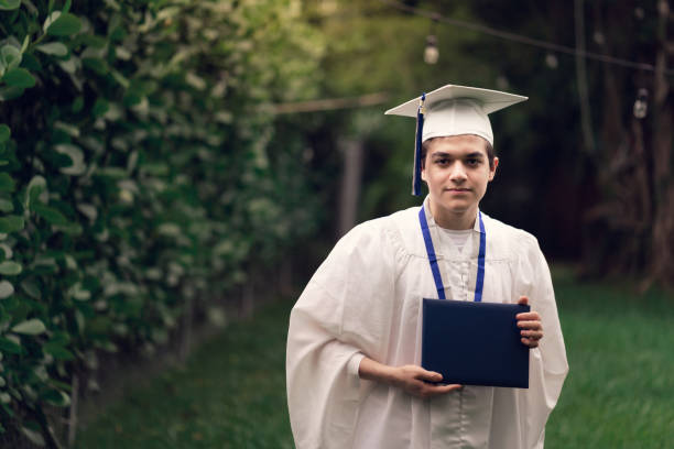 istock High school graduate holding diploma during covid-19 1251657017