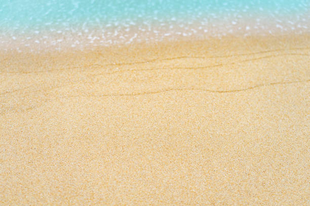 istock close up sand beach with blue sea wave background 1251657690