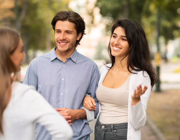 Girl Talking With Married Couple Of Friends Walking Outside Friendship With Ex. Girl Talking With Married Couple Of Friends Walking In Park Outside. Selective Focus jealous ex girlfriend stock pictures, royalty-free photos & images