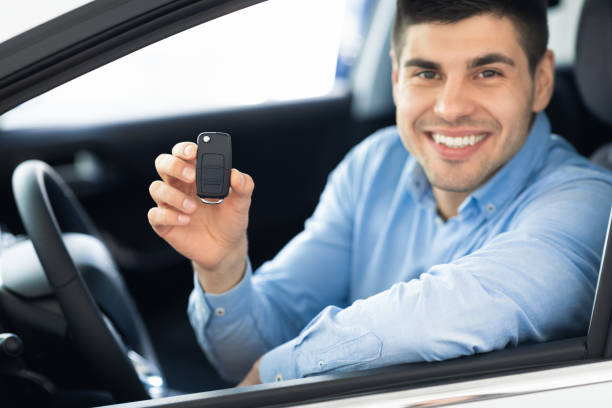 istock Joyful Man Showing Key Sitting In Driver's Seat 1251662992