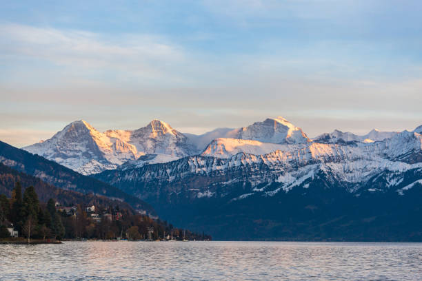atemberaubender panoramablick auf berühmte schweizer alpengipfel auf dem berner oberland eiger nordwand, monch, jungfrau bei sonnenuntergang vom thunersee an einem sonnigen herbsttag mit blauer himmelswolke,bern, schweiz - bernese oberland thun oberland panoramic stock-fotos und bilder