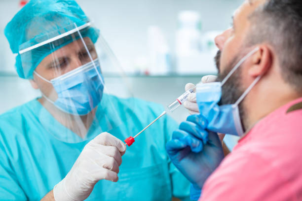 istock Doctor opening COVID-19 test kit to take saliva sample from patient 1251663216