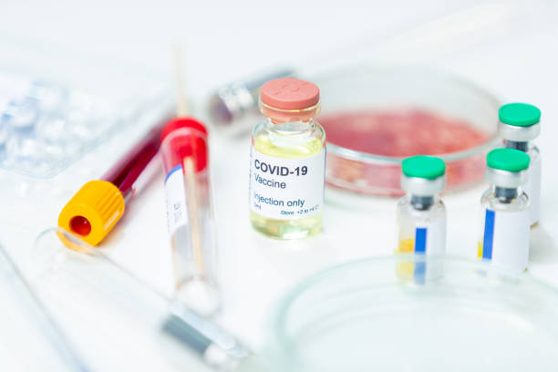 istock COVID-19 vaccine vials and testing equipment on white lab desk 1251663258