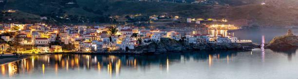 panorama der inselbelichterstadt andros, griechenland - sea aegean sea night illuminated stock-fotos und bilder