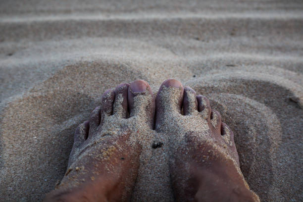 istock Close-up of feet’s in sand on beach 1251665050