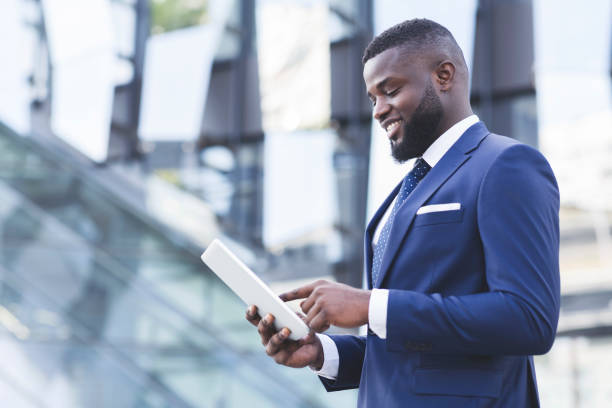 istock Pleased Black Businessman Using Digital Tablet Standing Outdoors, Copy Space 1251666130