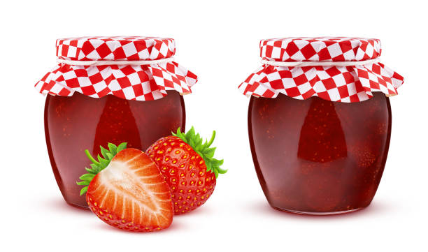 Glass jar of strawberry fruit jam isolated on white background with clipping path, covered with paper