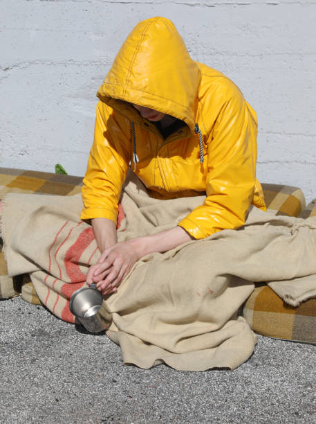 istock wanderer in the yellow raincoat Asks pedestrians  for alms 1251666786