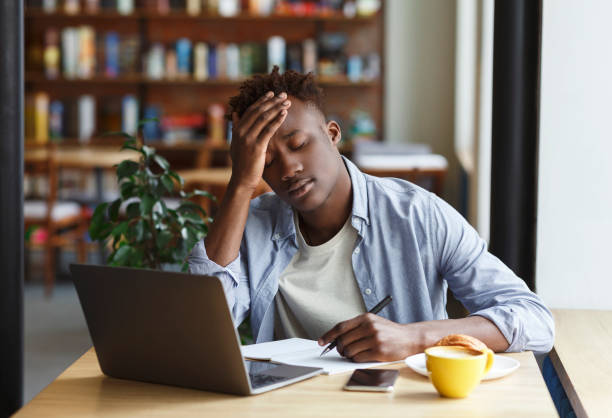istock Exhausted African American guy studying for exam in cafe 1251667486