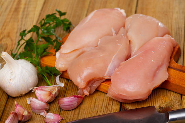 istock Raw chicken breast on wooden table 1251667959