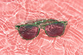 green sun glasses under pink water