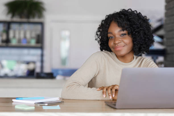 istock Pretty african girl posing at cafe while working with laptop 1251669961