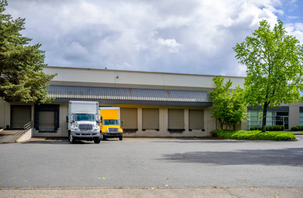 istock Small rigs semi trucks with box trailers standing in warehouse dock for loading cargo for delivery 1251671493