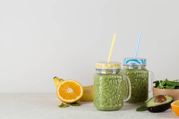 istock Green smoothie on gray background with avocado, spinach, banana, orange. 1251672821