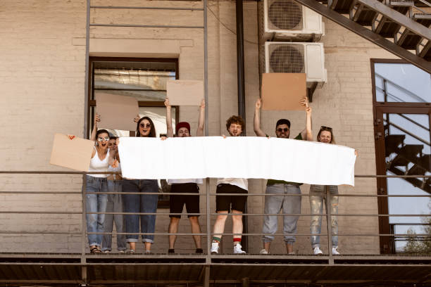 istock Diverse group of people protesting with blank signs. Protest against human rights, abuse of freedom, social issues 1251674974
